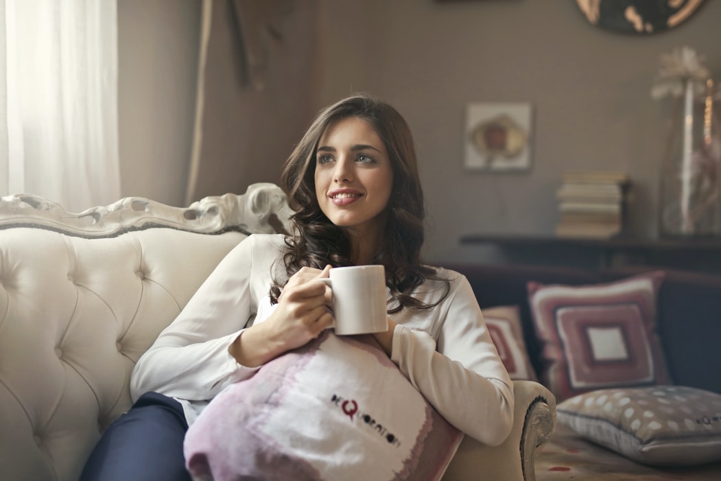 woman at home in lounge, relaxing, holding mug